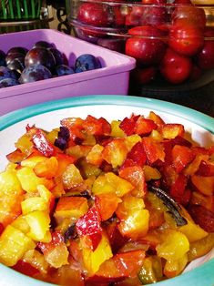 a bowl filled with fruit sitting on top of a table next to containers of fruit