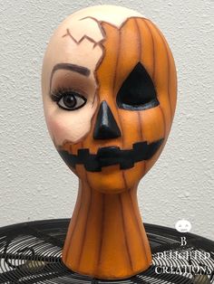 a carved pumpkin head sitting on top of a fan