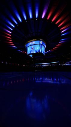 the ice rink is lit up with blue and red lights