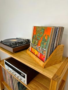 a record player is sitting on top of a wooden shelf