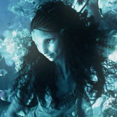 a woman with long hair standing under water