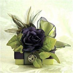 a purple rose and some green leaves on top of a book with a ring in it