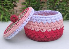 two crocheted baskets sitting next to each other on top of a white table