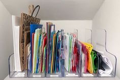 a bunch of folders that are sitting on a shelf in a room with white walls