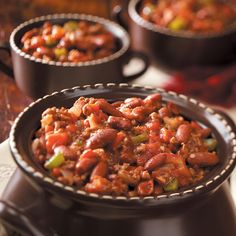 two bowls filled with chili and beans on top of a table