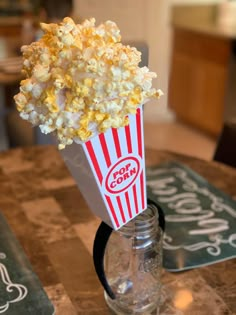 a glass jar filled with popcorn sitting on top of a table