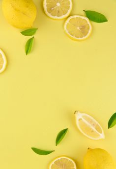 lemons and lime leaves on a yellow background