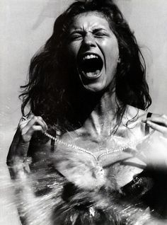 a woman with her mouth open and hands in front of her face as if she was screaming