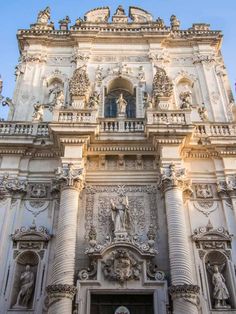 an ornate building with statues on the front