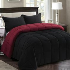 a bed with black and red comforters in a bedroom