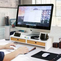 a person sitting at a desk with a computer monitor and keyboard in front of them