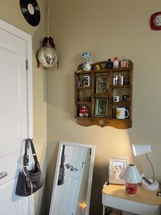 a room with a desk, chair and shelf on the wall next to a door