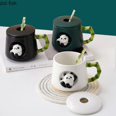 three coffee mugs with panda faces on them