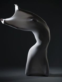 a white sculpture is shown against a black background with light coming from it's mouth