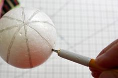 a person holding a white ball with a needle in it