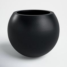 a black vase sitting on top of a white table