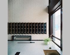 an empty room with several mailboxes on the wall and a plant next to it