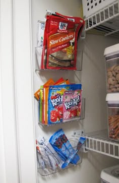 an open refrigerator door with food and snacks on the bottom shelf, along with freezer bins