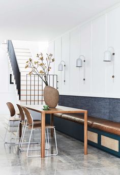 a dining room table with four chairs and a bench in front of the counter area