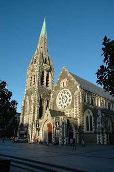 an old church with a steeple and stained glass window on the front, surrounded by trees