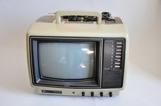 an old tv sitting on top of a white table