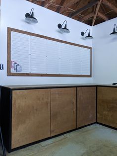 an empty room with wooden cabinets and lights on the wall next to eachother