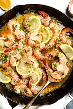 a skillet filled with shrimp and lemons