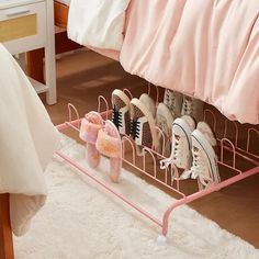 there is a pink rack with pairs of shoes on it in the room next to a bed