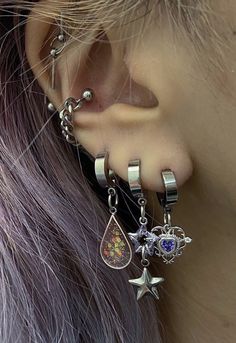 a close up of a person's ear with piercings and jewelry on it