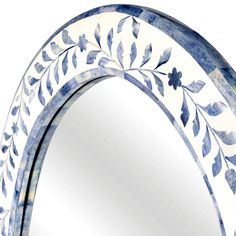 an ornate blue and white mirror with leaves on it