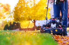 a man is mowing the grass with his lawnmower in autumntime time