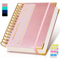 a pink notebook with gold trim and matching stickers