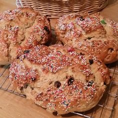 several cookies with sprinkles sitting on a wire rack next to a basket