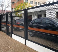 a car is parked behind a fence in front of a building