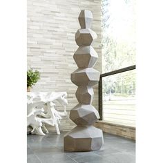 a tall sculpture sitting on top of a tiled floor