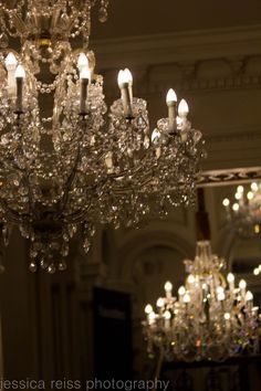 a chandelier hanging from the ceiling in a room with many lights on it