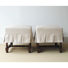 a pair of foot stools sitting next to each other on top of a carpeted floor