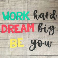 the words work hard, dream big, and be you are written on wood planks