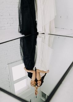 a woman is standing in front of a mirror with her feet up on the floor