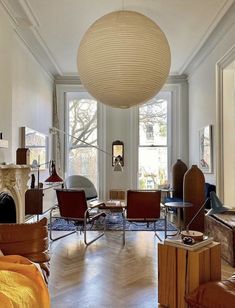 a living room filled with lots of furniture and a large round light fixture hanging from the ceiling