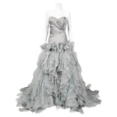 A truly magnificent, unworn with tags Oscar de la Renta dove-grey silk and tulle bustier strapless tiered ballgown dating back to his 2013 resort collection. As shown, the stunning Emma Watson wore a very similar dove-gray gown for the London premiere of Harry Potter And The Deathly Hallows. Oscar de la Renta was one of the world's leading fashion designers. Trained by Cristóbal Balenciaga and Antonio Castillo, he became internationally known in the 1960's as one of the couturiers to dress Jacqu Gray Gown, Cristobal Balenciaga, Vintage Evening Gowns, Grey Gown, Vintage Dress Design, Cristóbal Balenciaga, Strapless Bustier, Designer Evening Dresses, Vintage Gowns