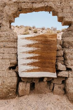 a piece of cloth hanging from the side of a stone wall in an open area