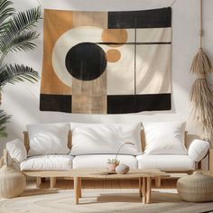 a living room with white couches and a large tapestry hanging on the wall above it