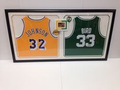 two basketball jerseys are hanging on the wall in front of a framed plaque that says bird and 32