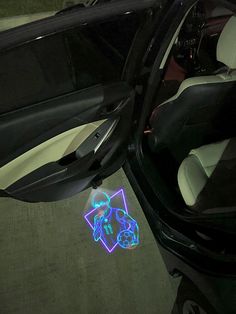 the interior of a car is lit up with blue and green lights on it's door