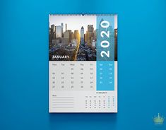 a calendar hanging on the wall with cityscape in the background