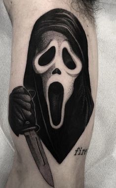 a person with a knife in their hand and a ghost face on his leg,