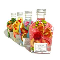 four bottles filled with different types of fruit and candy on top of each other in front of a white background