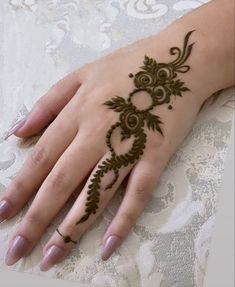 a woman's hand with henna tattoos on it