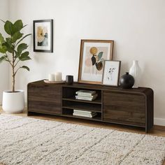 a living room with a rug, vases and pictures on the wall